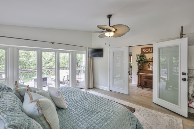 bedroom with ceiling fan, lofted ceiling, french doors, and light hardwood / wood-style flooring