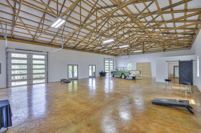 interior space with a barn door and high vaulted ceiling