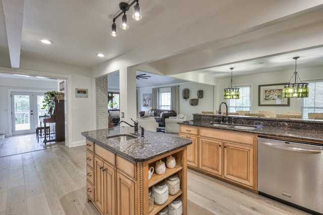 kitchen featuring pendant lighting, dishwasher, light wood-type flooring, and sink