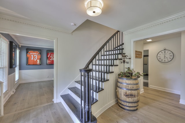 stairway with hardwood / wood-style floors, plenty of natural light, and ornamental molding