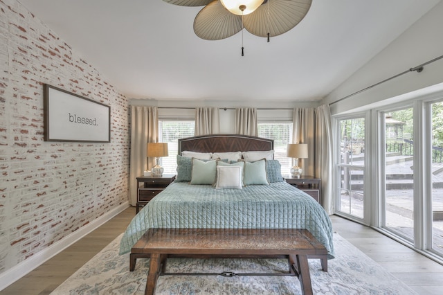 bedroom featuring access to exterior, ceiling fan, light hardwood / wood-style flooring, and vaulted ceiling