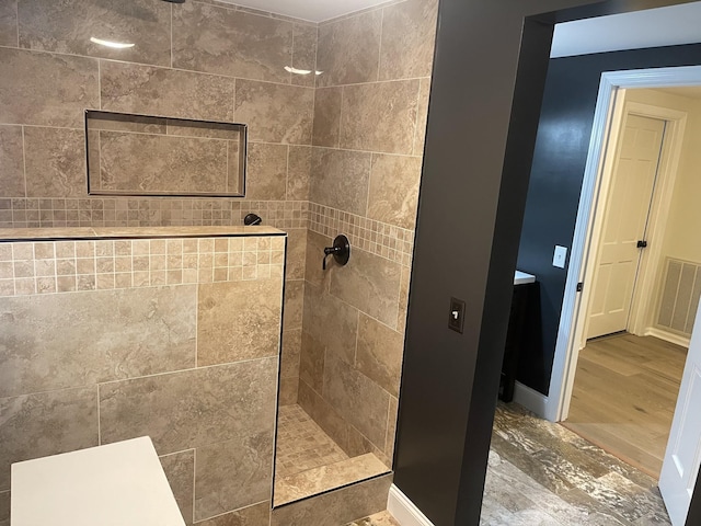 bathroom featuring tiled shower and hardwood / wood-style flooring