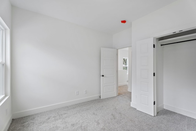 unfurnished bedroom featuring light carpet