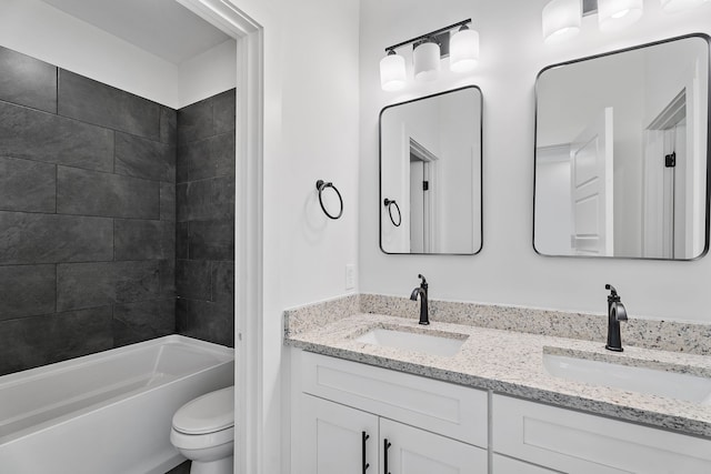 full bathroom with vanity, tiled shower / bath combo, and toilet