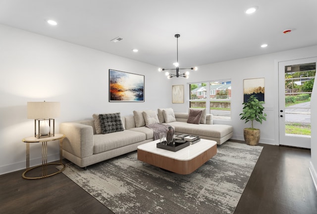 living room featuring a notable chandelier and dark wood-type flooring