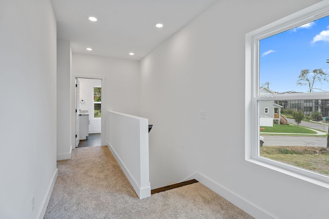 hallway with light carpet and plenty of natural light