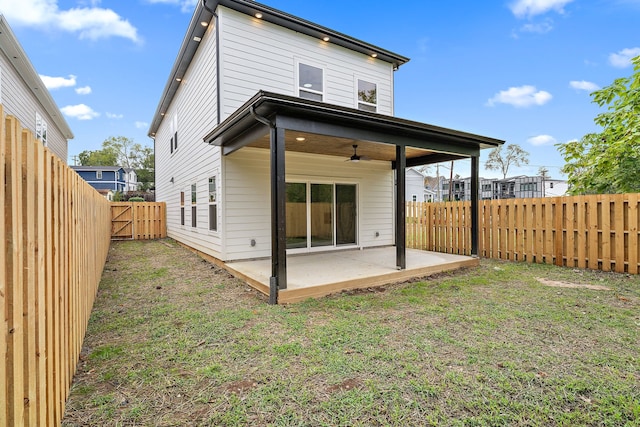 back of property with ceiling fan, a yard, and a patio area