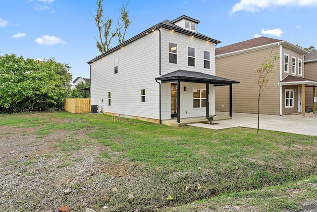 rear view of house with a yard, a patio area, and central AC