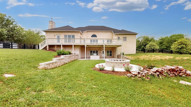 back of house with a lawn, a deck, and a patio area