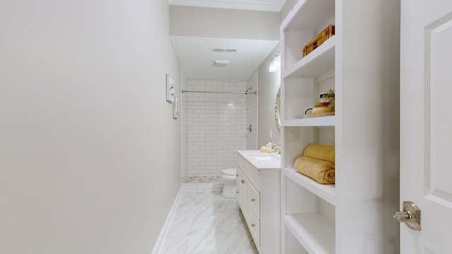 bathroom with vanity, toilet, and tiled shower