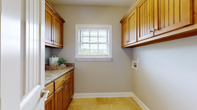 washroom with washer hookup and cabinets