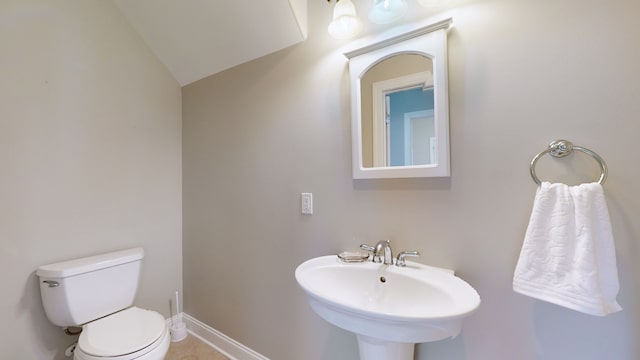 bathroom with vaulted ceiling, sink, and toilet