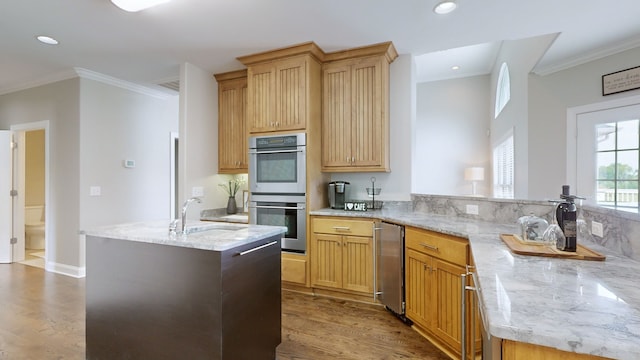 kitchen with light stone counters, double oven, sink, and kitchen peninsula