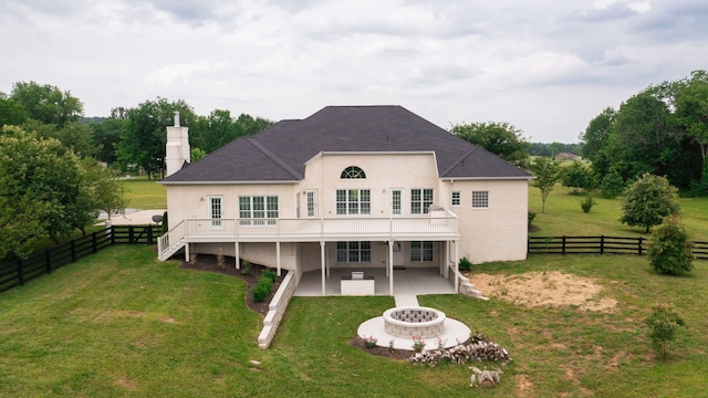 back of property featuring a lawn, a patio, and an outdoor fire pit