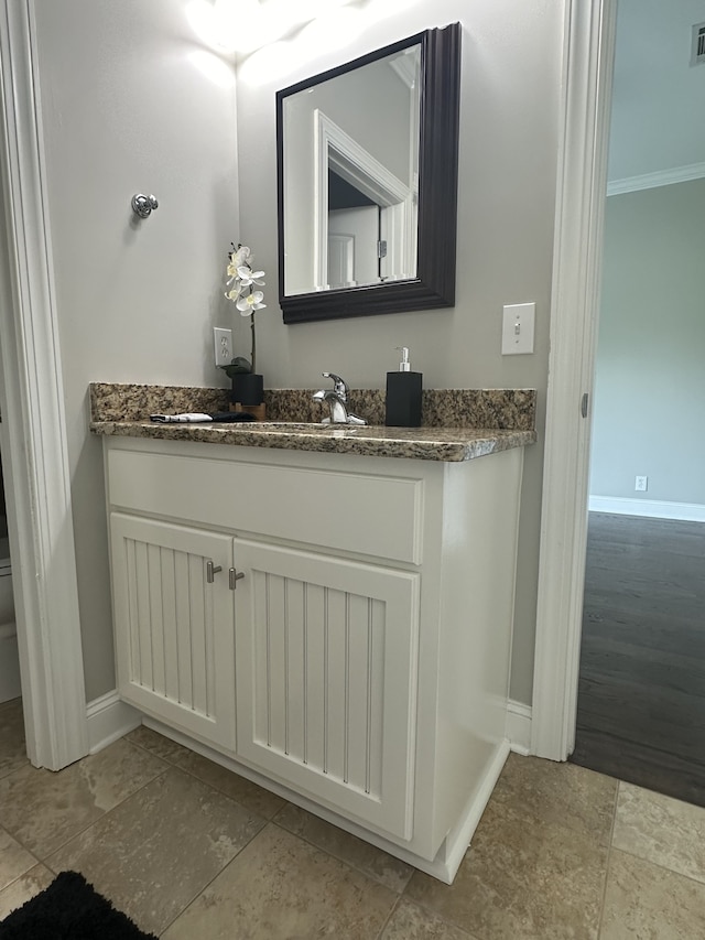 bathroom featuring toilet, hardwood / wood-style flooring, vanity, and crown molding