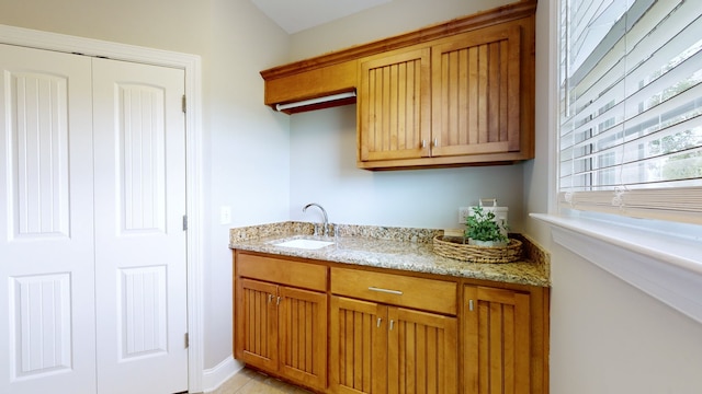 kitchen featuring light stone countertops and sink