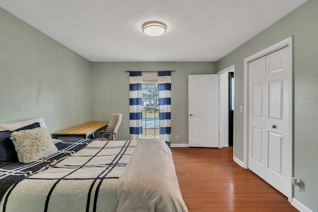 bedroom with hardwood / wood-style flooring, a textured ceiling, and a closet