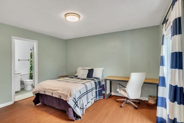 bedroom featuring wood-type flooring and ensuite bathroom