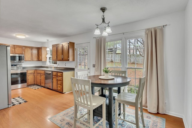 kitchen featuring sink, a chandelier, hanging light fixtures, light hardwood / wood-style floors, and stainless steel appliances