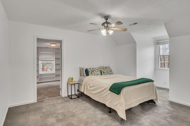 carpeted bedroom featuring ceiling fan and a textured ceiling