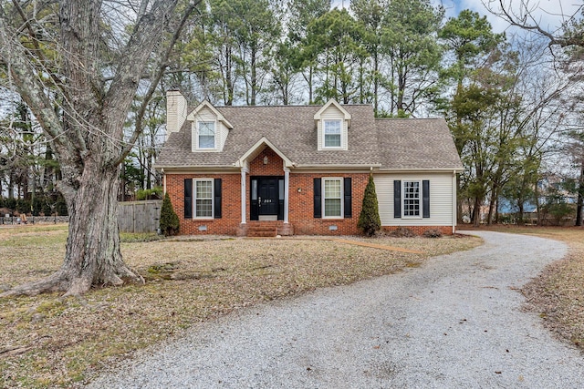 cape cod house with a front yard