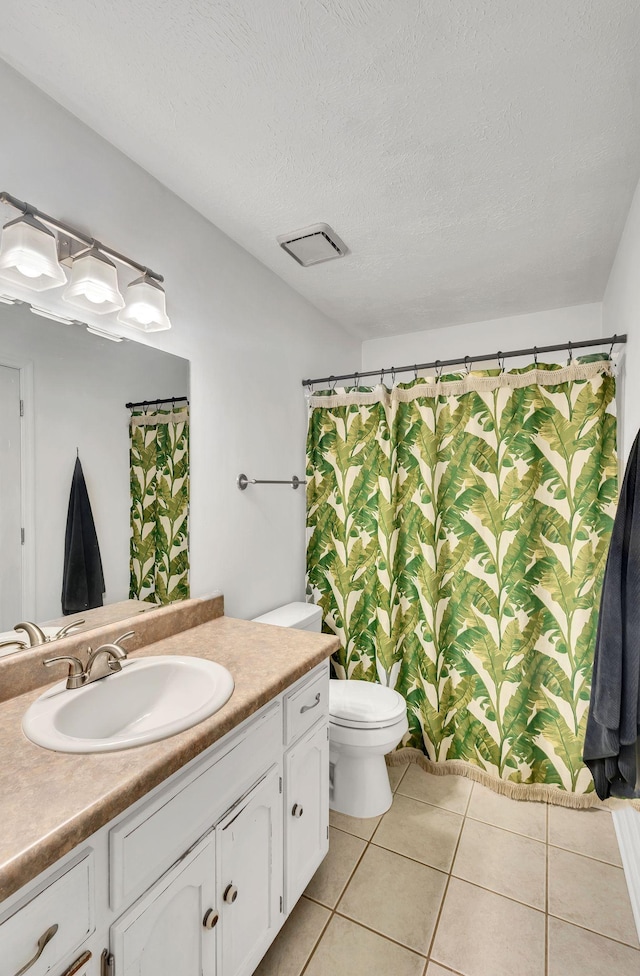 bathroom with toilet, a textured ceiling, vanity, a shower with shower curtain, and tile patterned flooring