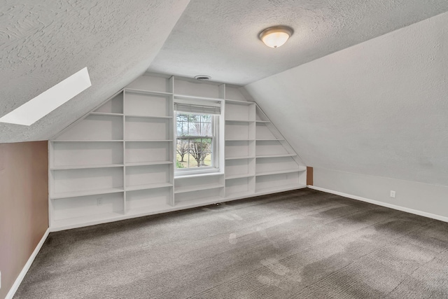 additional living space with built in shelves, carpet floors, lofted ceiling with skylight, and a textured ceiling