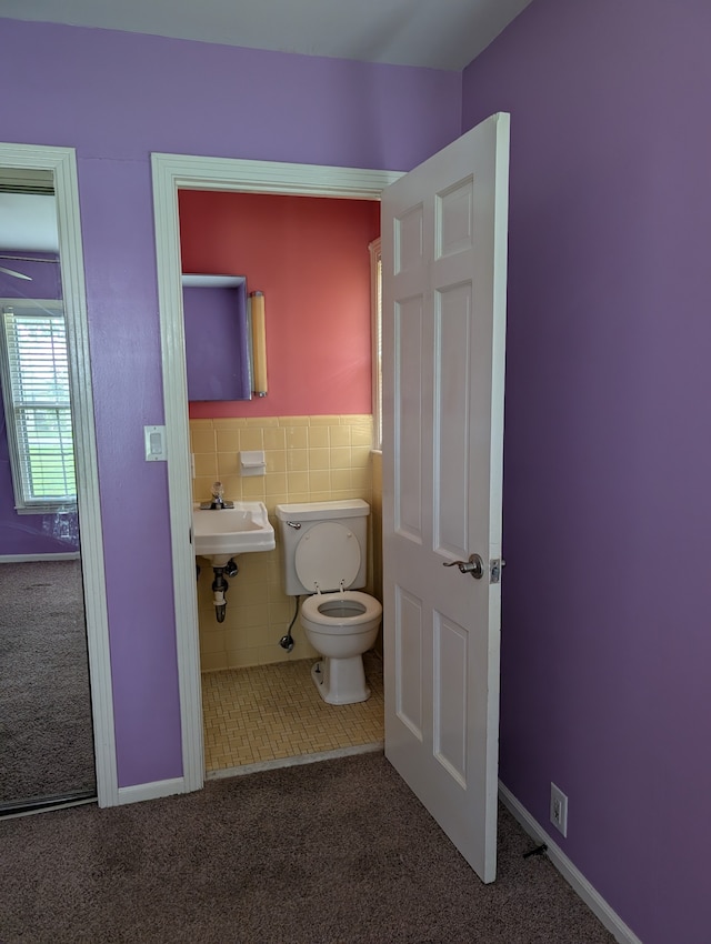 bathroom with sink, tile walls, and toilet