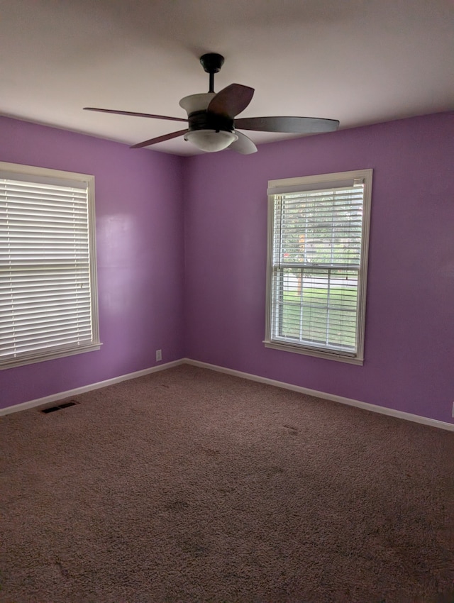 carpeted spare room featuring ceiling fan