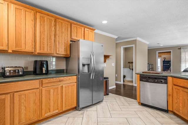 kitchen featuring a textured ceiling, stainless steel appliances, light wood-type flooring, crown molding, and decorative backsplash