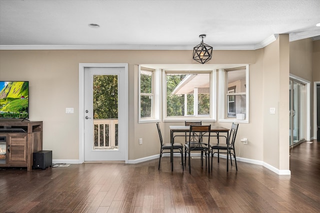 dining space with a textured ceiling, ornamental molding, and dark hardwood / wood-style floors