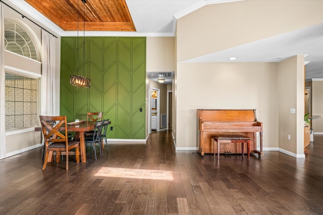 dining room with a towering ceiling, crown molding, and dark wood-type flooring