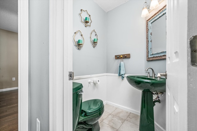 bathroom featuring a textured ceiling, toilet, and tile patterned floors