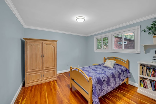 bedroom with wood-type flooring and crown molding