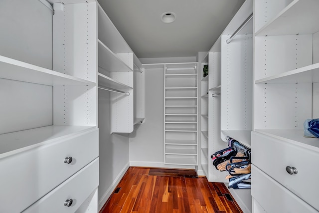 walk in closet with dark hardwood / wood-style flooring