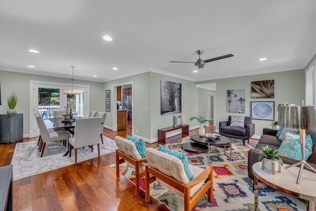 living room with ceiling fan, ornamental molding, and hardwood / wood-style floors