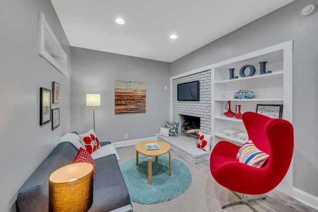 living room with a brick fireplace and wood-type flooring