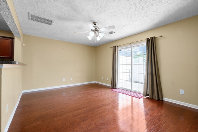 unfurnished room featuring a textured ceiling, dark hardwood / wood-style flooring, and ceiling fan