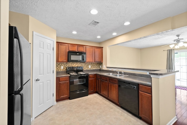 kitchen with a textured ceiling, sink, kitchen peninsula, light hardwood / wood-style flooring, and black appliances