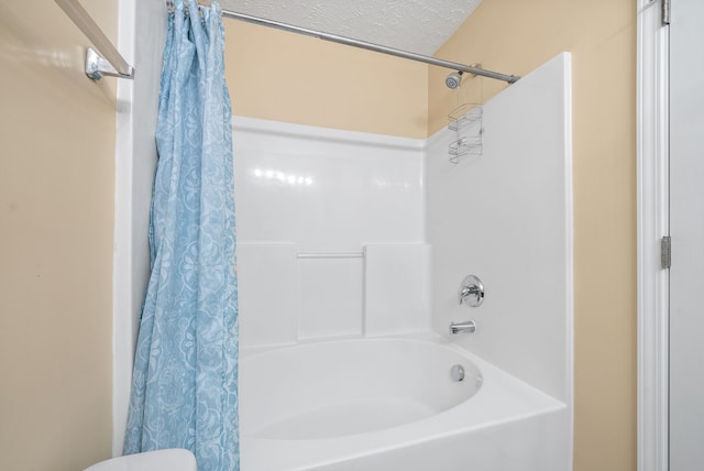 bathroom with a textured ceiling, toilet, and shower / bath combination with curtain