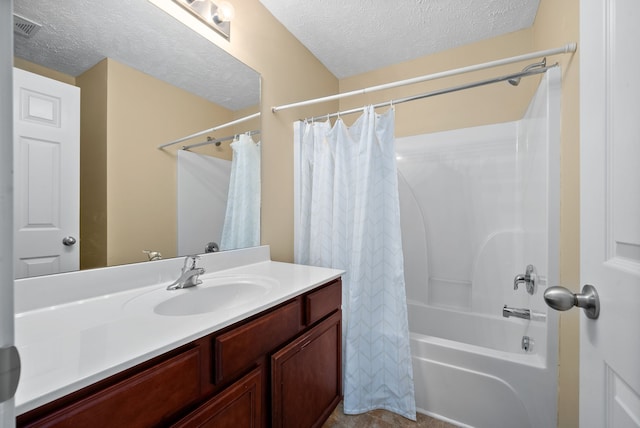 bathroom featuring shower / tub combo with curtain, a textured ceiling, and vanity