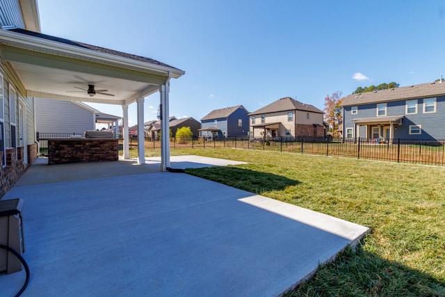 view of yard with an outdoor kitchen, ceiling fan, and a patio area