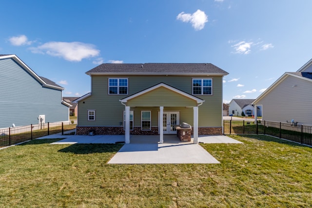 rear view of property with french doors, a yard, and a patio area