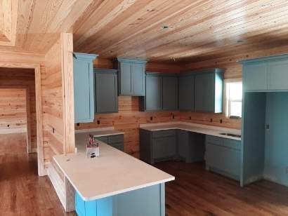 kitchen featuring wood walls, a kitchen island, wood ceiling, blue cabinetry, and dark hardwood / wood-style flooring