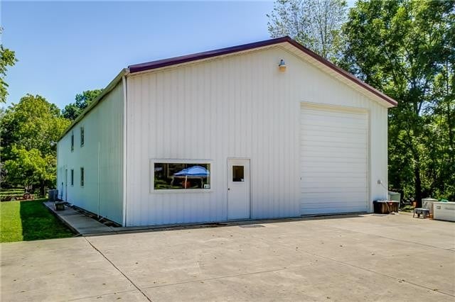 view of property exterior featuring a garage and an outdoor structure