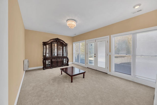 sitting room featuring light colored carpet and french doors