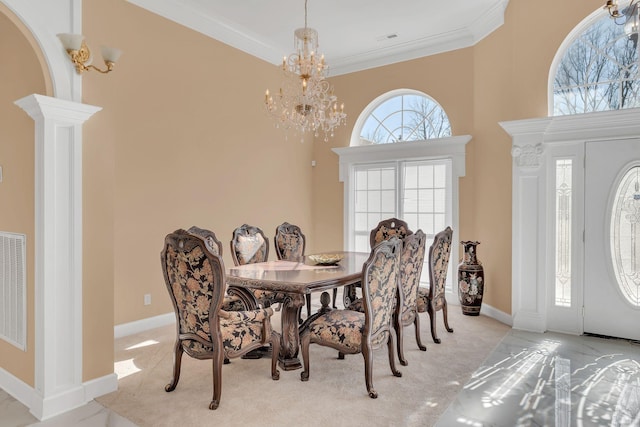 dining room featuring ornate columns, ornamental molding, light carpet, and a notable chandelier