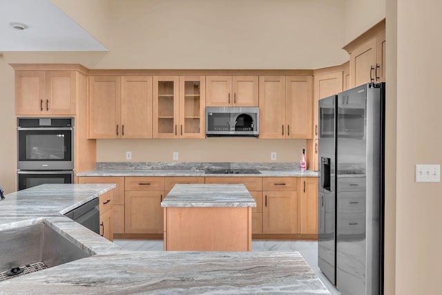 kitchen featuring appliances with stainless steel finishes, light brown cabinetry, and sink