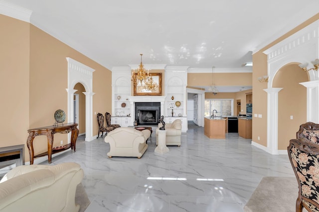 living room featuring ornate columns, ornamental molding, sink, and built in features