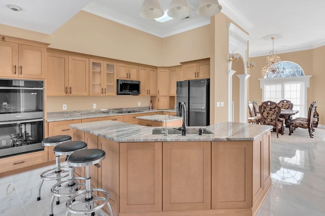 kitchen with appliances with stainless steel finishes, an island with sink, sink, hanging light fixtures, and light stone counters